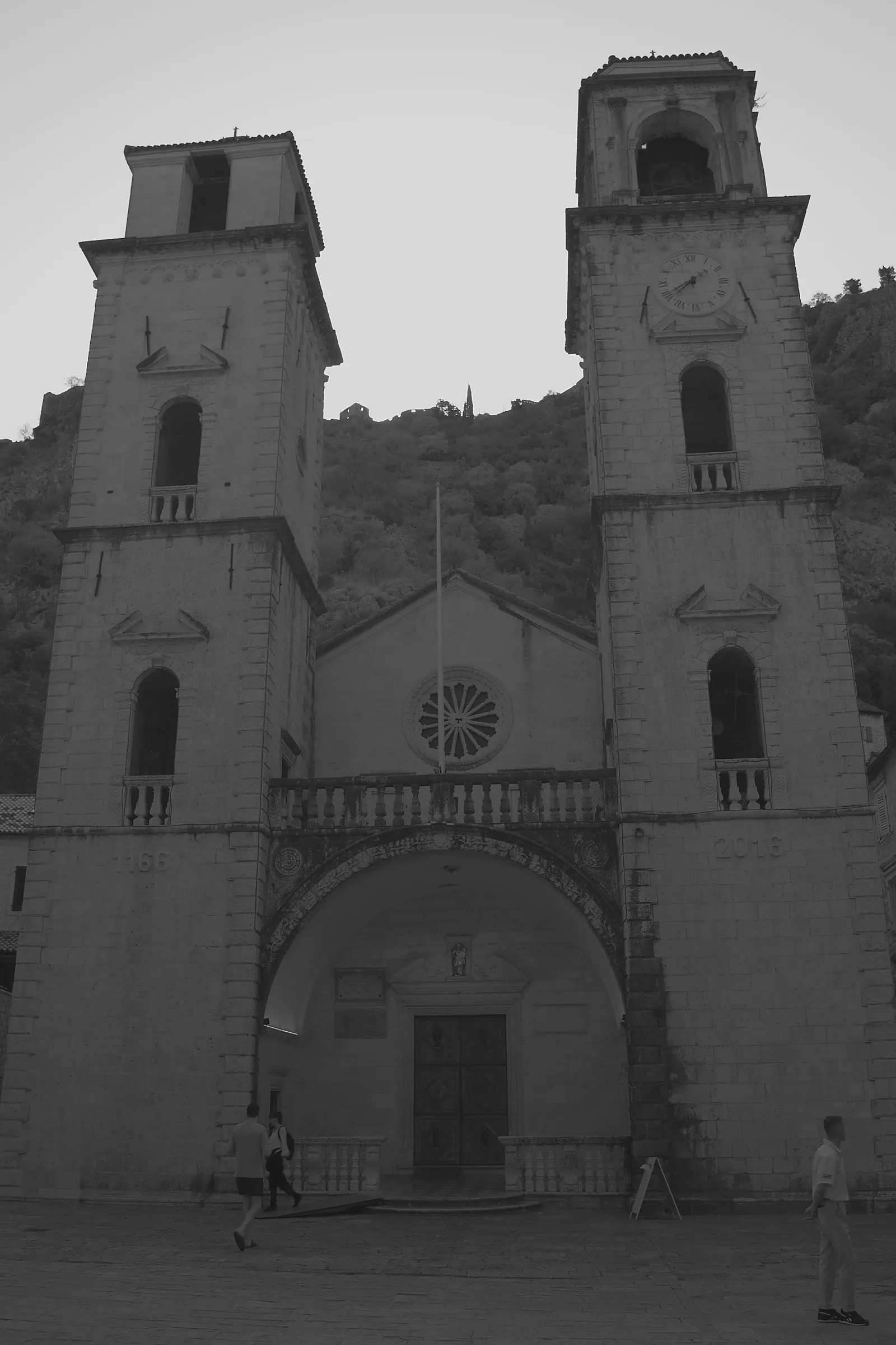 La facciata della cattedrale di San Trifone a Cattaro, con le due torri campanarie disuguali e la montagna alle spalle
